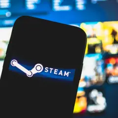 Smartfon z logo Steam na tle gier. Chcesz wiedzieć, jak wyłączyć Big Picture Steam?