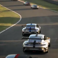 Wyścigowe Porsche na torze, w tle inne samochody. Emocje jak w Assetto Corsa Evo.