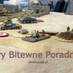 Miniaturowe czołgi i żołnierze na pustynnym polu bitwy. Sceneria do figurkowych gier bitewnych.