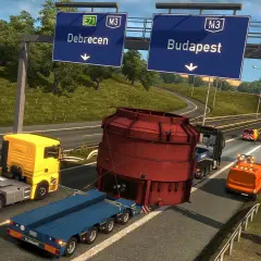 Transport ciężkiej maszyny w Euro Truck Simulator 3. Ciężarówka z żółtą kabiną i niebieską naczepą przewozi ogromny czerwony element.