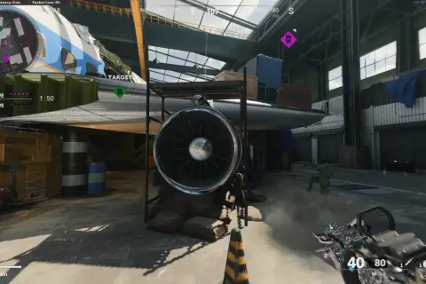 Gracz w Call of Duty World at War biegnie przez hangar z samolotem, celując z broni.