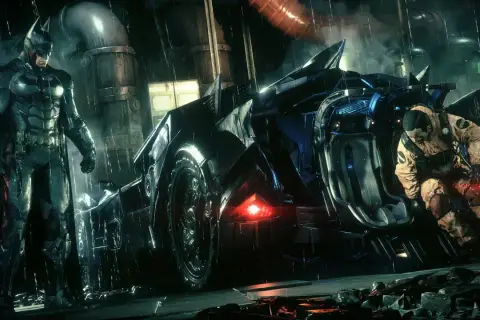 Batman w deszczu przy Batmobilu, gotowy do akcji w Arkham City. Obok niego klęczy mężczyzna w pomarańczowym kombinezonie.