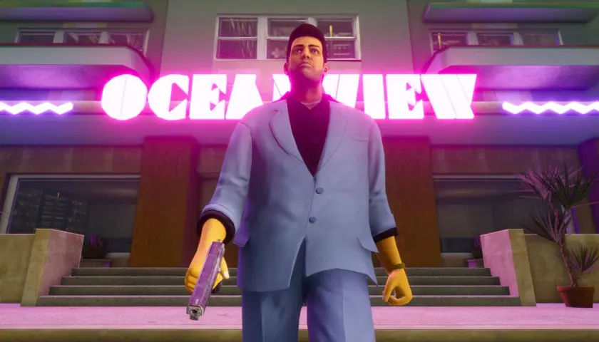 Tommy Vercetti z GTA Vice City Definitive Edition stoi przed neonowym napisem "OCEAN VIEW", trzymając pistolet.