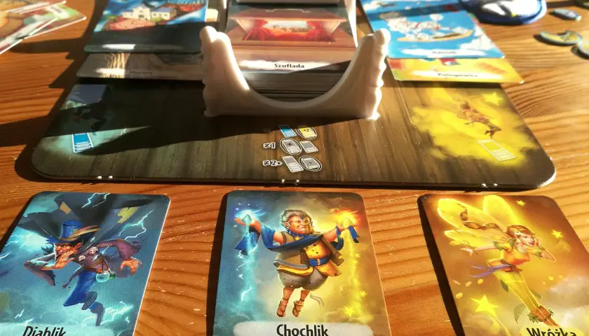 Kraina snów gra: Diablik, Chochlik i Wróżka na stole. Karty i plansza tworzą magiczny świat.