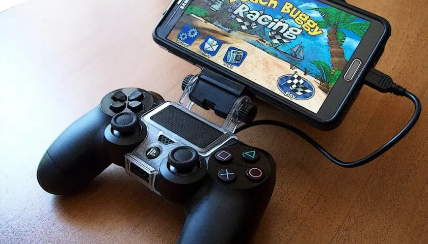 Smartfon z grą "Beach Buggy Racing" podłączony do kontrolera. Idealny zestaw do grania w top gry na androida.