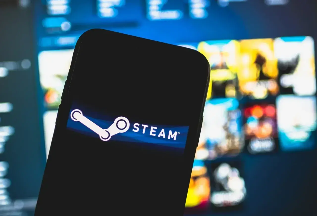 Smartfon z logo Steam na tle gier. Chcesz wiedzieć, jak wyłączyć Big Picture Steam?
