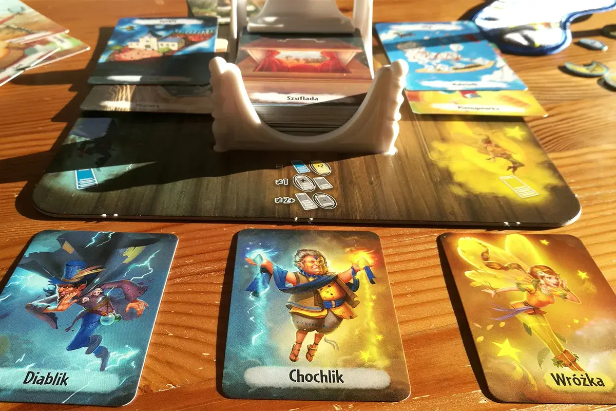 Kraina snów gra: Diablik, Chochlik i Wróżka na stole. Karty i plansza tworzą magiczny świat.