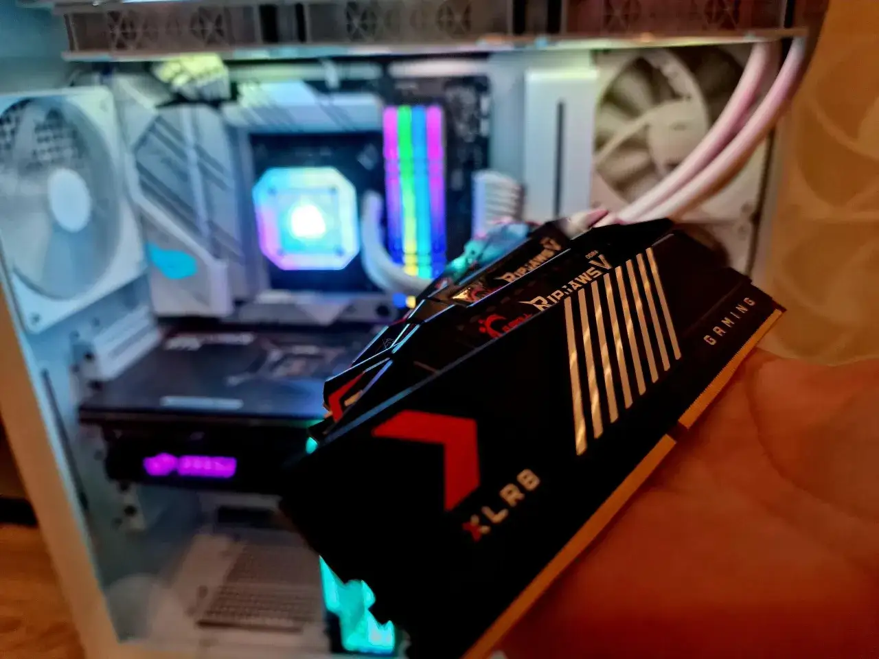 Chcesz wiedzieć, jak sprawdzić jaki mam RAM? Oto moduły G.Skill Ripjaws V. W tle widać komputer z podświetleniem RGB.