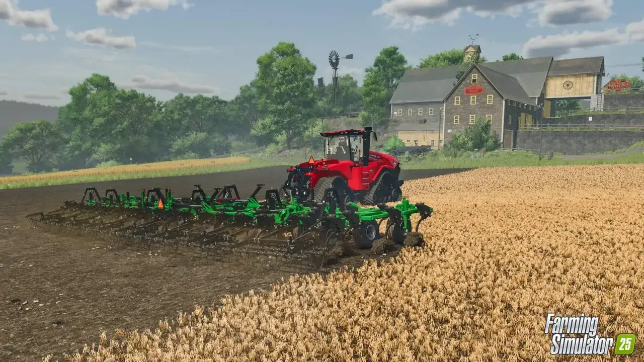 Czerwony traktor z szerokim pługiem orze pole w grze Farming Simulator 25 PS4. W tle farma i wiatrak.