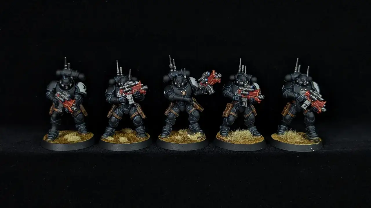 Pięciu rycerzy w czarnych zbrojach, każdy z czerwonym karabinem, gotowych do walki. Jeden z nich, black templar marshal, dowodzi oddziałem.