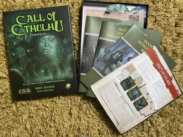 Zestaw startowy Call of Cthulhu, gotowy na mroczne przygody. W środku podręczniki, karty i kości.